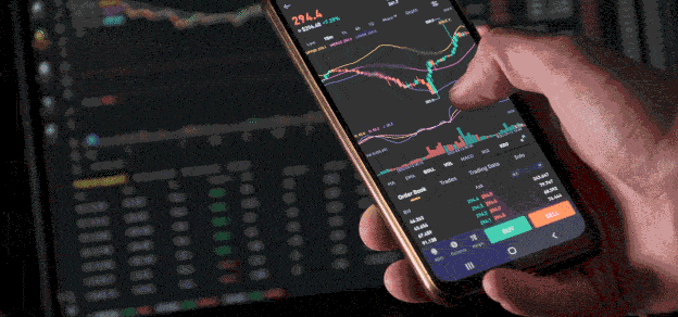A trader confidently holding his mobile device displaying live data through TradeCopier, a tool for seamless and effective trading. 