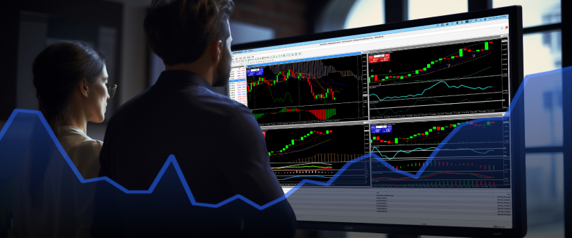 Two people observing a stock chart on a monitor, focused on financial data and market analysis.