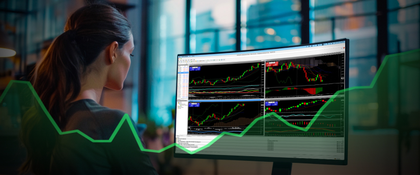 Una mujer analiza un gráfico bursátil que aparece en la pantalla de su ordenador, centrada en los datos financieros y las tendencias.