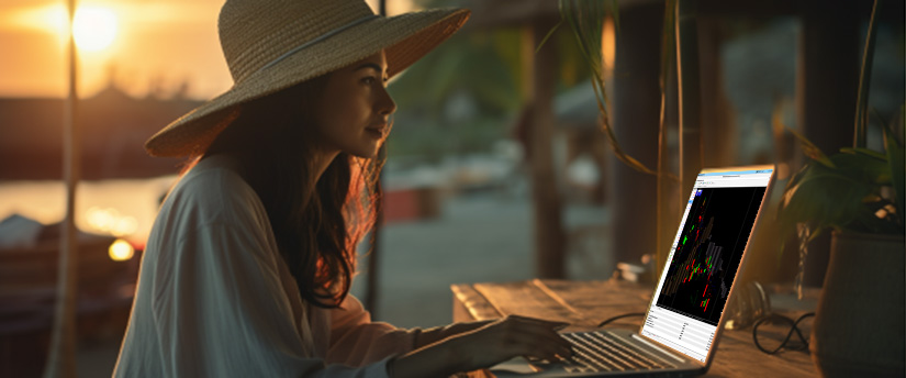 Une femme coiffée d'un chapeau travaille sur son ordinateur portable, concentrée sur l'écran.