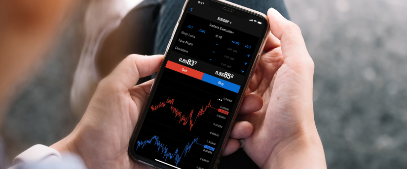 Person holding a smartphone displaying a forex trading app with EUR/GBP chart and buy-sell options.